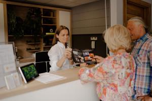 a group of people standing around a counter with a woman at WYDMA Resort Medi & SPA - Normobaria in Mrzeżyno