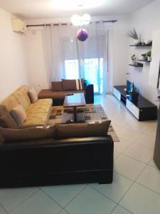 a living room with a couch and a table at ALPHA CITY CENTER APARTMENT in Shkodër