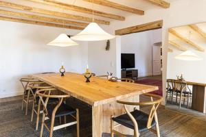 uma sala de jantar com uma mesa de madeira e cadeiras em Bohemian Chic Family Villa by CadenzaLux em Cascais