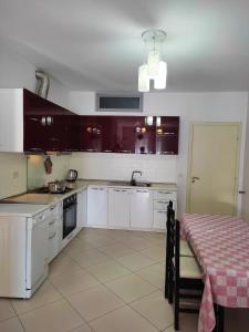 a kitchen with white cabinets and a table with a table cloth at ALPHA CITY CENTER APARTMENT in Shkodër