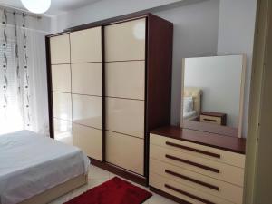 1 dormitorio con 1 cama y vestidor con espejo en ALPHA CITY CENTER APARTMENT, en Shkodër