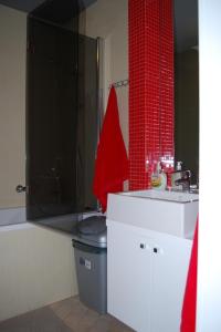 La salle de bains est pourvue d'un lavabo et d'un mur en carrelage rouge. dans l'établissement Apartament Słoneczna Skarpa, à Rabka-Zdrój