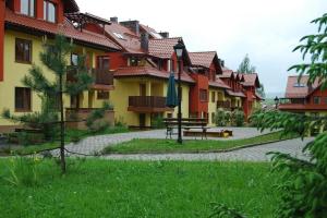 Une rangée de maisons avec une table de pique-nique dans l'herbe dans l'établissement Apartament Słoneczna Skarpa, à Rabka-Zdrój