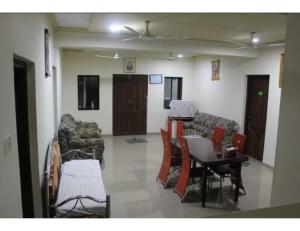 een woonkamer met een bank en een tafel en stoelen bij AR Resort & Restaurant, Gauchar in Chutwāpīpal