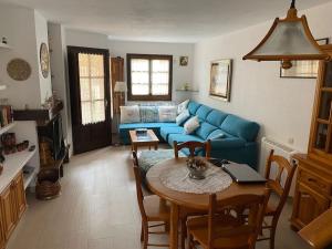 a living room with a blue couch and a table at Casa con jardín en Roda de Bará in Roda de Bará