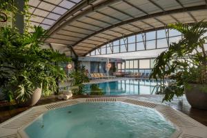 una grande piscina in un edificio con una grande piscina coperta di Crowne Plaza Tel Aviv Beach, an IHG Hotel a Tel Aviv