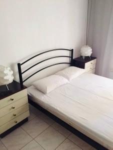 een slaapkamer met een bed en twee nachtkastjes met twee lampen bij Mk apartment in Asprovalta