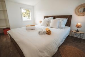 a bedroom with a large white bed with towels on it at Kaz Lucie 1 & 2, avec piscine et magnifique vue in Saint-Pierre