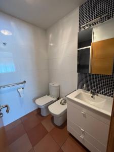 a bathroom with a white toilet and a sink at Casa Marina in Cerdido +15 photos