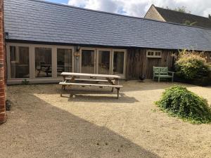a picnic bench in front of a building at The Dairy-Petting Farm-Indoor Pool-Play Areas-Parkland-Woodland-Lake,Ponds&Stream-min2 night stay in Lechlade