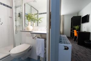 アムステルダムにあるムルタトゥリ ホテルの白いバスルーム(トイレ、シンク付)