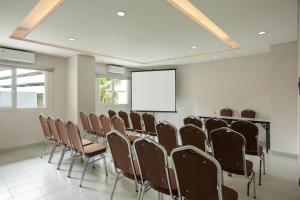 a conference room with a row of chairs and a screen at Amaris Hotel Kalimalang in Jakarta