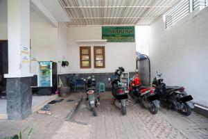 eine Gruppe von Motorrädern, die vor einem Gebäude geparkt sind in der Unterkunft RedDoorz Syariah near PGC Cililitan in Jakarta