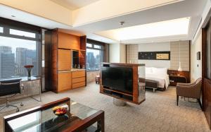 a hotel room with a television and a bed at InterContinental Foshan, an IHG Hotel - Free Shuttle Bus for Canton Fair in Foshan