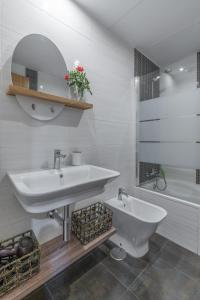 biała łazienka z umywalką i prysznicem w obiekcie tuGuest Postigo I Catedral Apartment w Grenadzie