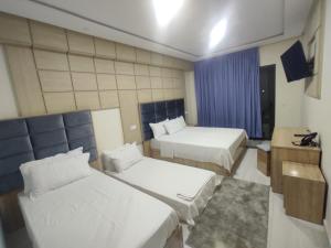 una camera d'albergo con due letti e una finestra di FEKRI HOTEL a Meknès