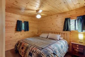 1 dormitorio con 1 cama en una cabaña de madera en Lakefront Cabin and Cottages, en Greenville