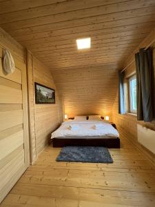 Un dormitorio con una cama en una cabaña de madera. en Osada Aurora Całoroczne domki z jacuzzi z widokiem na jezioro i góry, en Miszkowice 274 fotos más