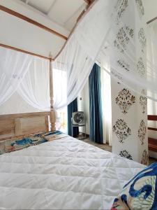 1 dormitorio con 1 cama blanca grande con cortinas en Villa Music of the ocean, en Wadduwa