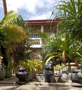瓦都瓦的住宿－Villa Music of the ocean，一座花园,在一座建筑前方设有雕像
