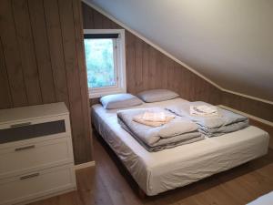 LiagardaneにあるStor og moderne hytte med panoramautsiktのベッドルーム1室(タオル付きのベッド1台、窓付)