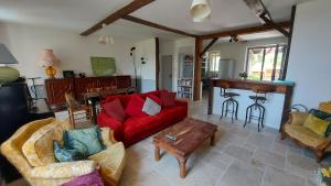 a living room with a red couch and a table at Vine maison 2 bedroom with ensuites in Saint-Julien-dʼEymet