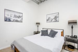 1 dormitorio con 1 cama blanca y 2 almohadas en Downtown Contemporary Coastal Oasis en Anchorage