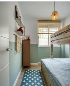 1 dormitorio con litera y alfombra azul en Casa Xava Valencia, en Valencia