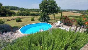 a swimming pool in the middle of a garden at Vine maison 2 bedroom with ensuites in Saint-Julien-dʼEymet