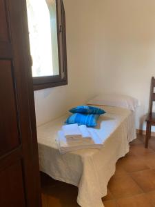 サン・テオドーロにあるCase Vacanze Villa Rositaの青い枕が付いたベッドが備わる客室です。