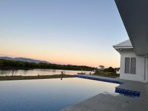 ein Haus mit einem Pool neben einem Fluss in der Unterkunft Lake Side Villa in Nadi