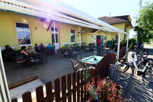 un patio avec des tables et des chaises et des personnes assises dans un restaurant dans l'établissement Restaurace Bowling Rakovec, à Řepiště
