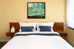 een slaapkamer met een wit bed met blauwe kussens bij Hotel Regina -Garni Köln in Keulen