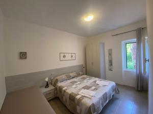 a bedroom with a bed and a window at Bed & Breakfast Alex in Capoliveri