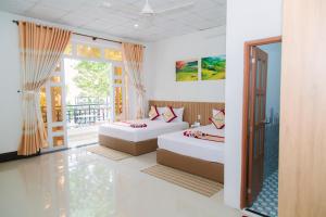 een slaapkamer met 2 bedden en een balkon bij Minh Minh Nam 2 Hotel in Can Tho