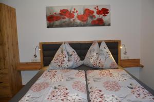 ノイキルヒェン・アム・グロースヴェンエーディガーにあるAppartement Wieshofのベッドルーム1室(赤と白の枕が備わるベッド1台付)