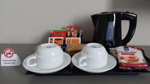 two cups and plates on a tray with a coffee maker at Eurohotel in Nichelino +17 photos