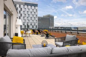 - une terrasse avec un canapé et des chaises dans un bâtiment dans l'établissement Adina Serviced Apartments Vienna, à Vienne