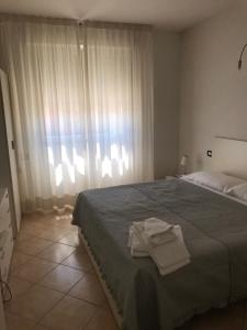 a bedroom with a bed with two towels on it at Residence il Tombolo in Principina a Mare