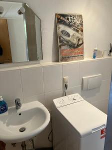 een witte badkamer met een wastafel en een spiegel bij FeWo Kronsberg in Eldingen