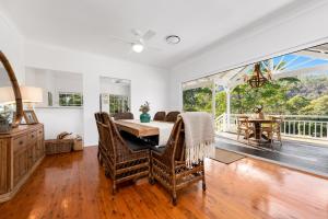 a dining room with a table and a large window at The Stables Luxury Country Escape in Canungra