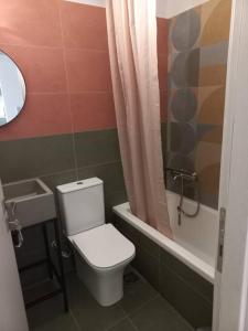 a small bathroom with a toilet and a bath tub at Centrally located apartment 2 in Volos
