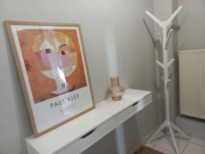 a white shelf with a picture and a vase on it at Centrally located apartment 2 in Volos