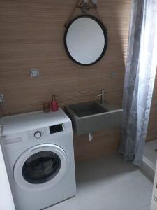 a bathroom with a washing machine and a sink at Centrally located apartment 2 in Volos