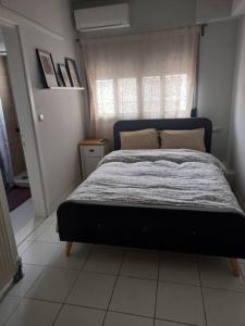 sypialnia z łóżkiem w pokoju z oknem w obiekcie Centrally located apartment 2 w mieście Wolos
