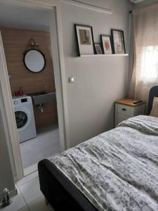 sypialnia z łóżkiem i pralką w obiekcie Centrally located apartment 2 w mieście Wolos