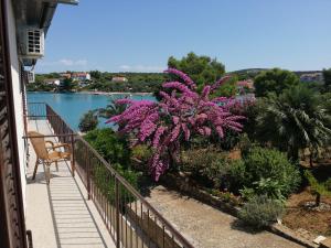 a balcony with purple flowers and a view of the water at Trim Rooms and Apartments in Lovište