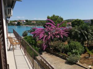 un balcón con flores púrpuras y vistas al agua en Trim Rooms and Apartments, en Lovište