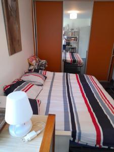 um quarto com uma cama e uma mesa com um candeeiro em Carpe Diem em Le Val-André