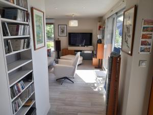 uma sala de estar com uma cadeira branca e estantes em Carpe Diem em Le Val-André